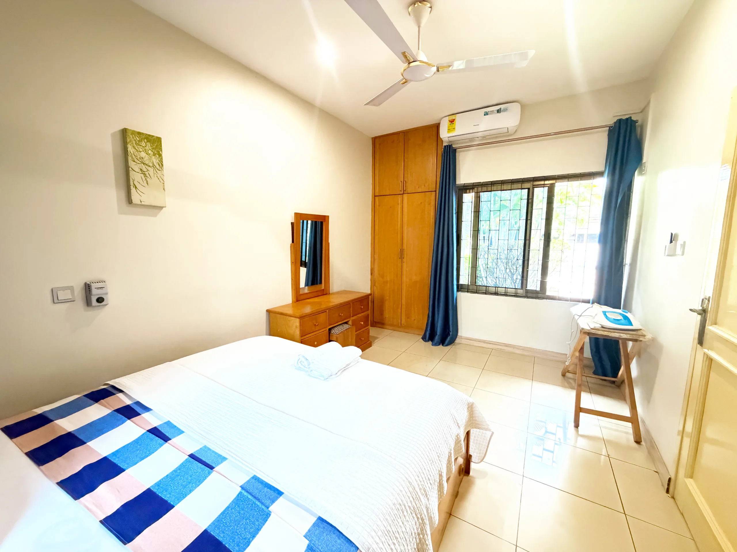 A double bed beside a fitted wardrobe and dressing table