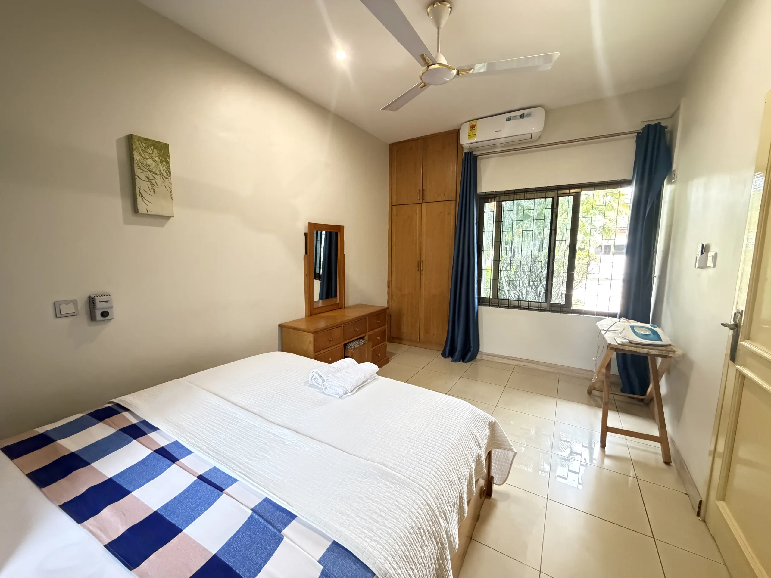 A made-up double bed with towels folded at its foot