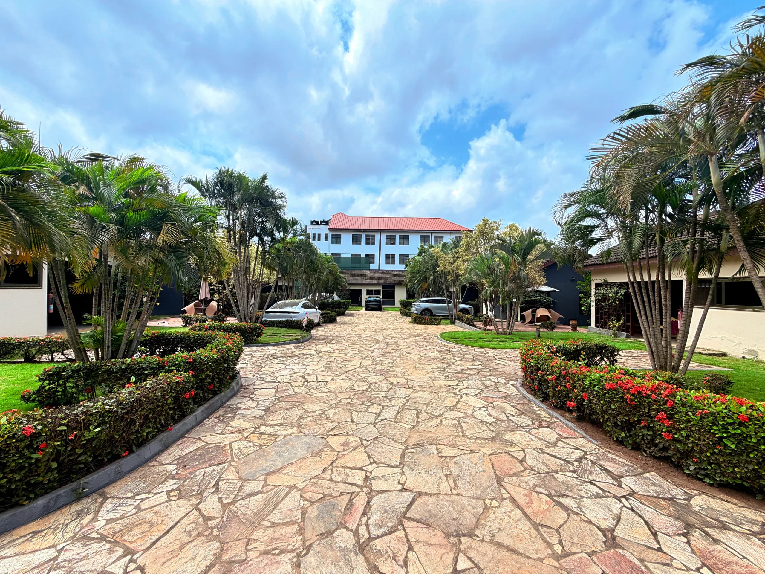The stone drive at Travellers’ Palm Court, lined with palms and flowering hedges