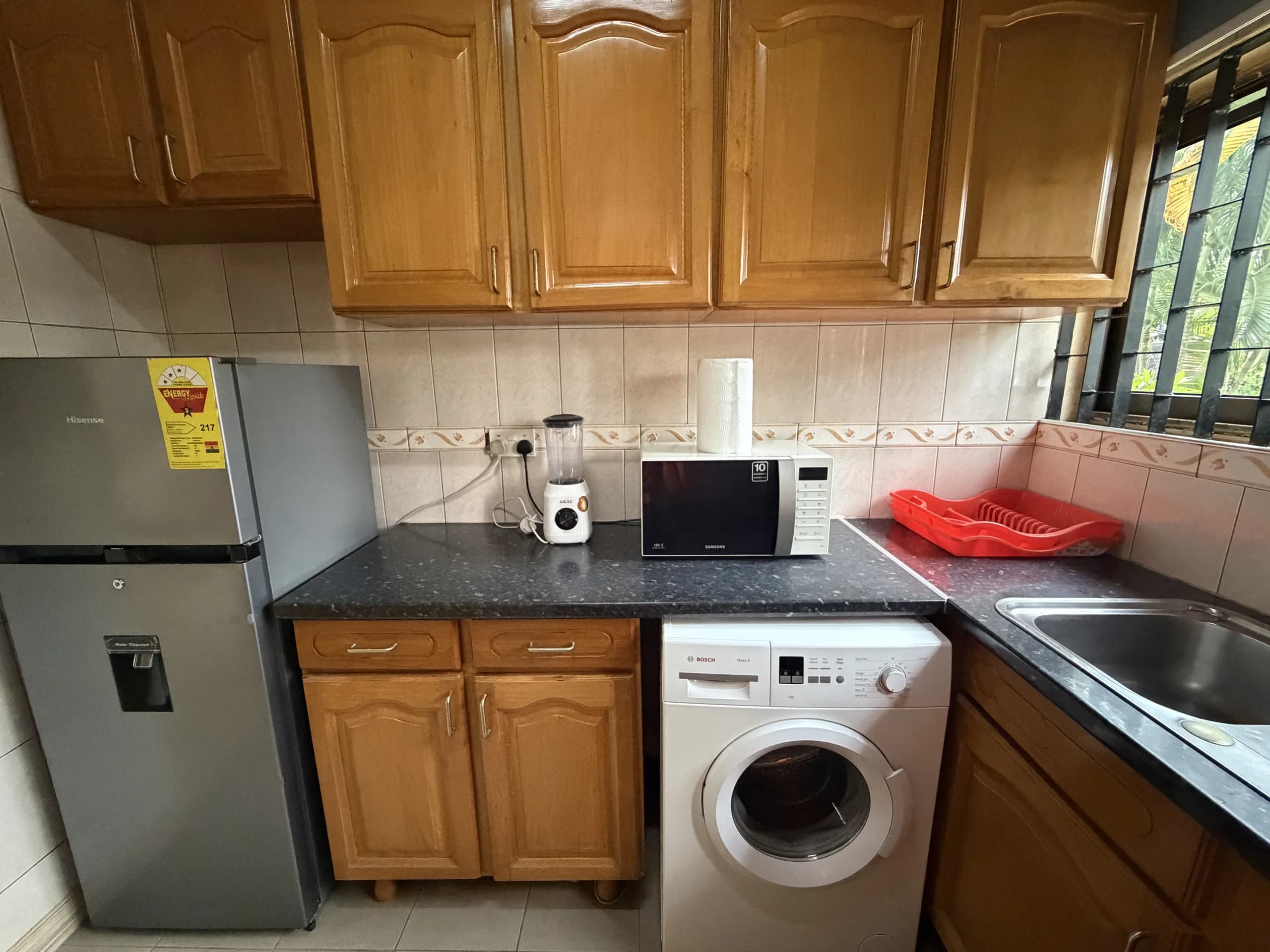 A fitted kitchen with fridge-freezer, microwave and washing machine